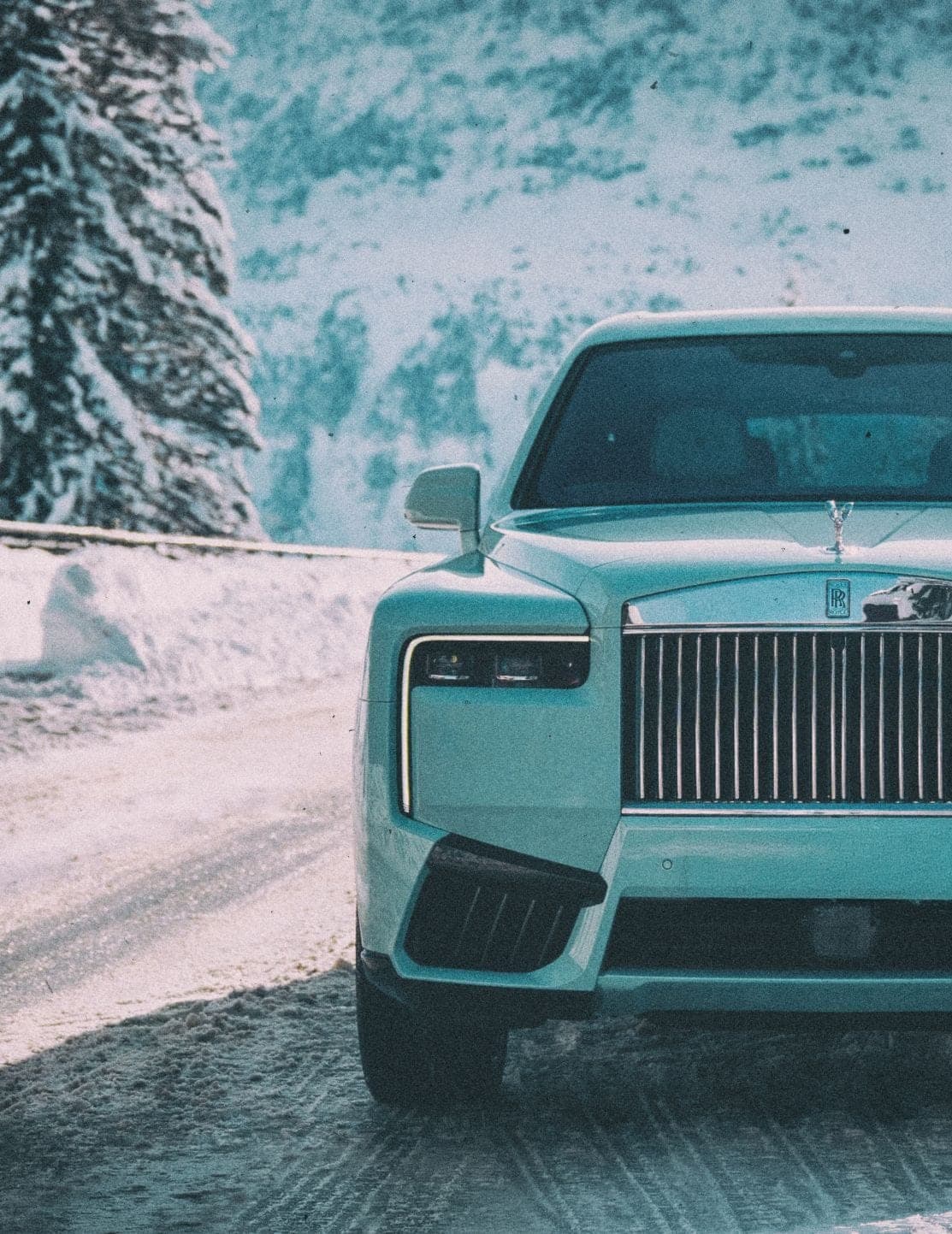 Glacier-blue Rolls-Royce on a snow-covered road