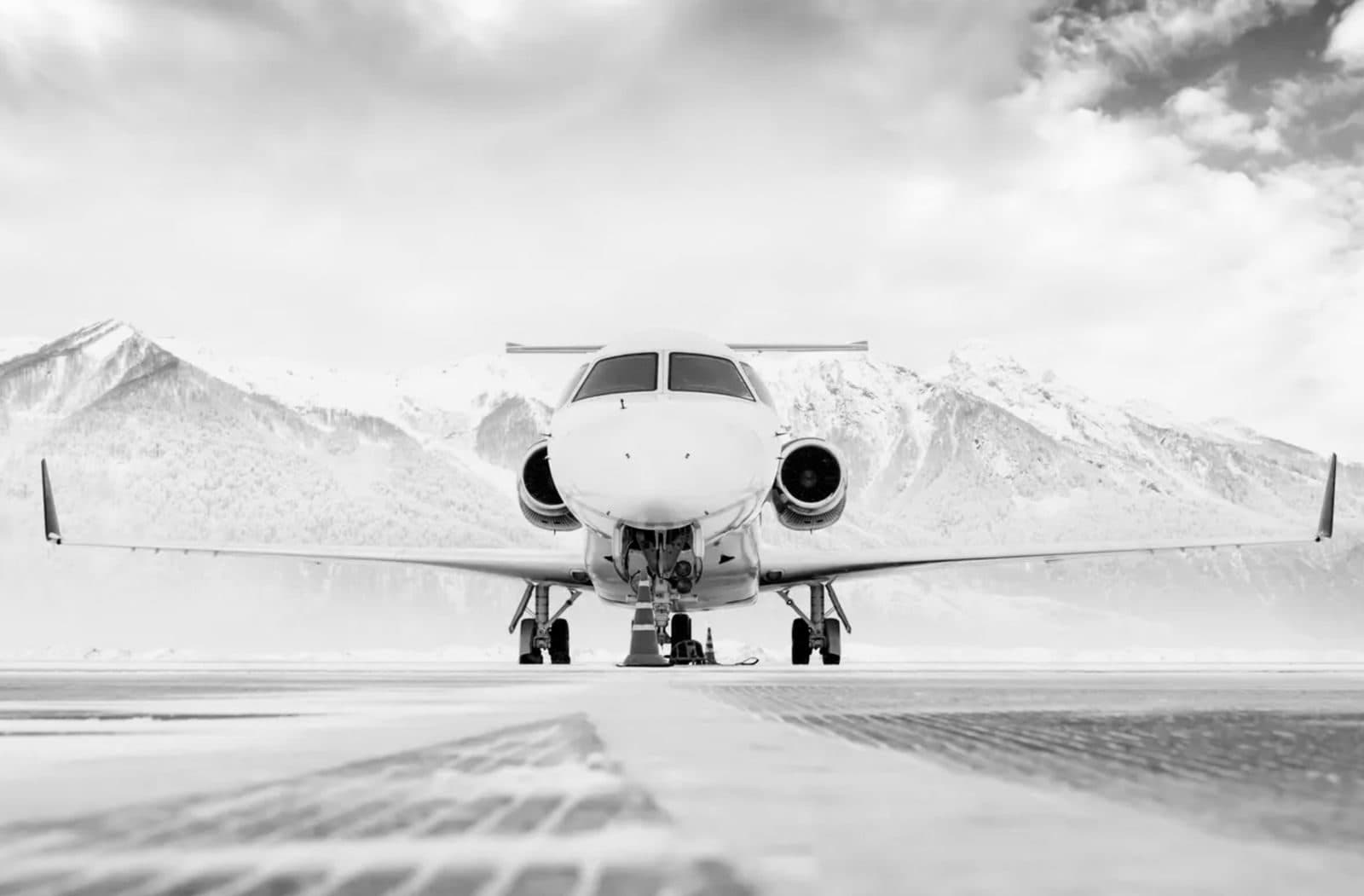Private jet on the altiport tarmac, snow-capped mountains